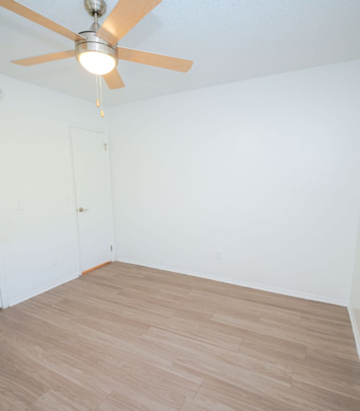 Empty bedroom with ceiling fan and two closet doors at Huntington Reserve in Sanford, Florida