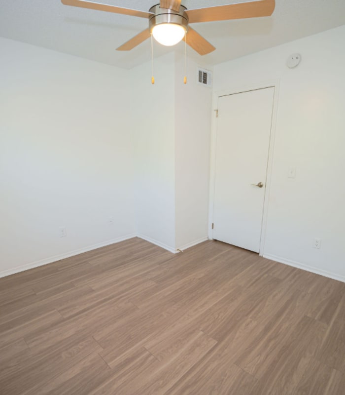 Empty bedroom corner with ceiling fan and two doors at Huntington Reserve in Sanford, Florida
