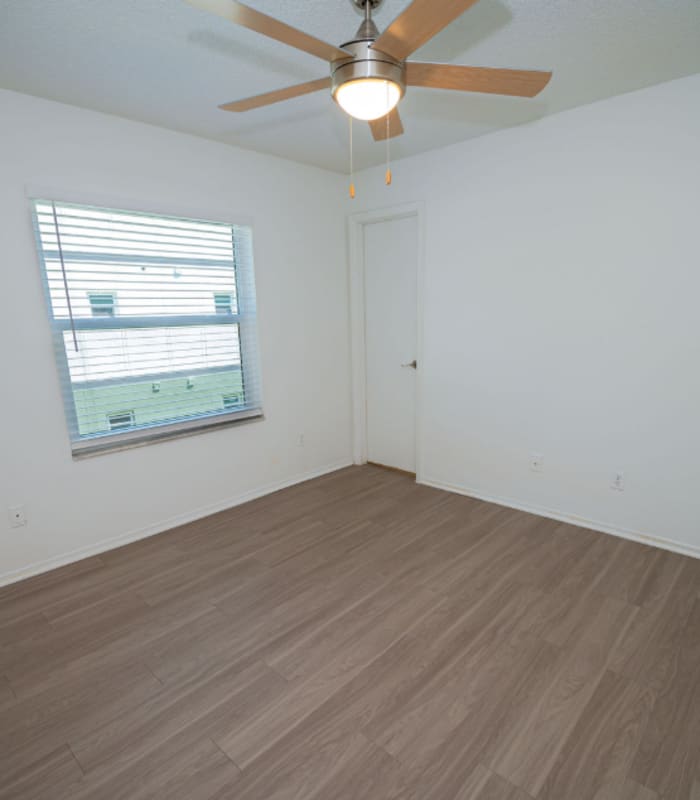 Empty bedroom with ceiling fan, window and closet door at Huntington Reserve in Sanford, Florida