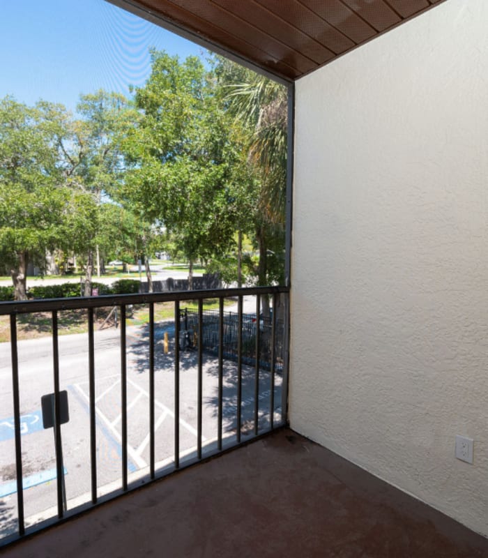 Screened balcony overlooking the parking lot with trees in the background at Huntington Reserve in Sanford, Florida
