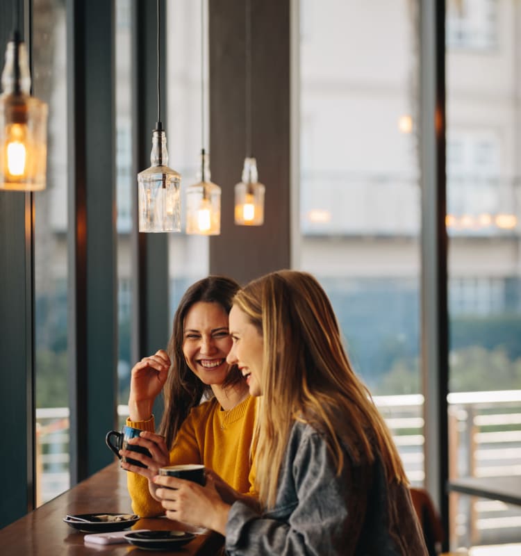 Two ladies enjoying coffee near at St. Tropez Apartments in Miami Lakes, Florida