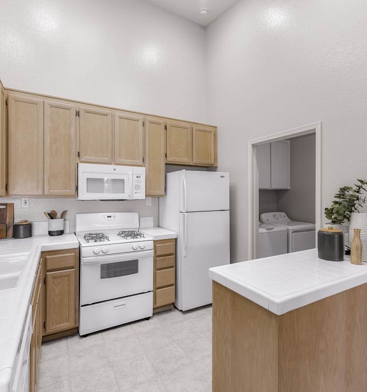 View of the dining area over the breakfast bar in a model home's kitchen at Sofi Canyon Hills in San Diego, California