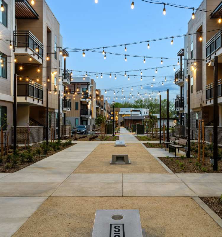 Cornhole courtyard with cafe lights at Phase 2 of Sutter Green in Sacramento, CA