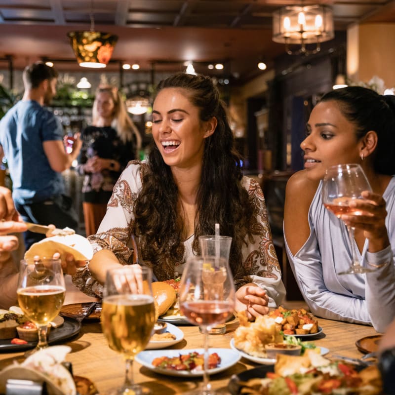 Friends getting drinks and food at a local hot spot near Harvest Station Apartments in Broomfield, Colorado