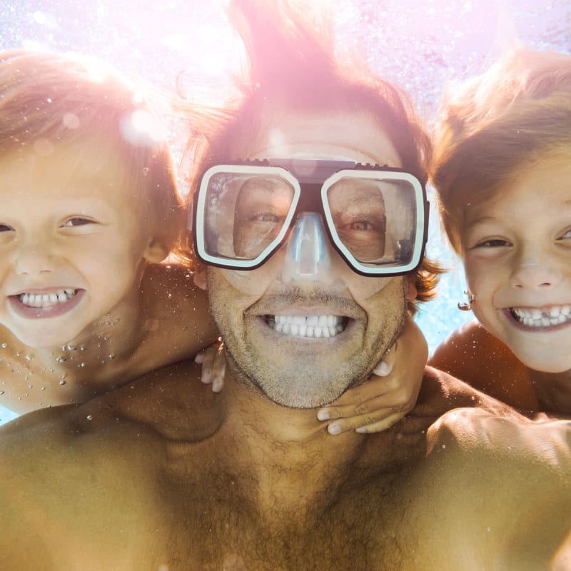 Dad and kids taking a cool under water photo at The Reserve at Ballenger Creek Apartments in Frederick, Maryland