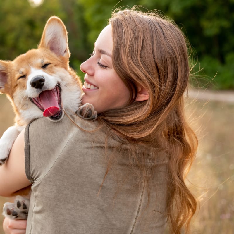 Woman holding her cute dog at The Reserve at Ballenger Creek Apartments in Frederick, Maryland