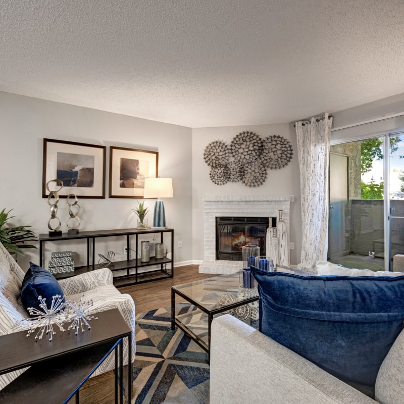 Well-furnished living area with a fireplace in a model home at Waterfield Court Apartment Homes in Aurora, Colorado