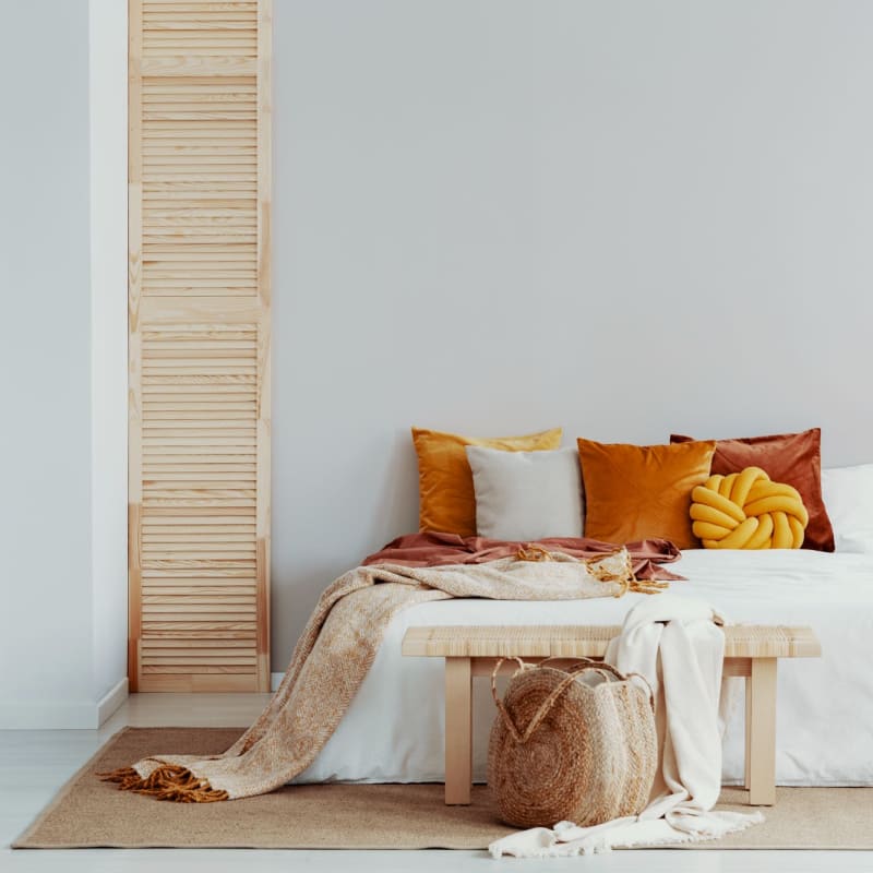 Model bedroom with orange accents at Burrell Square in Rome, Georgia