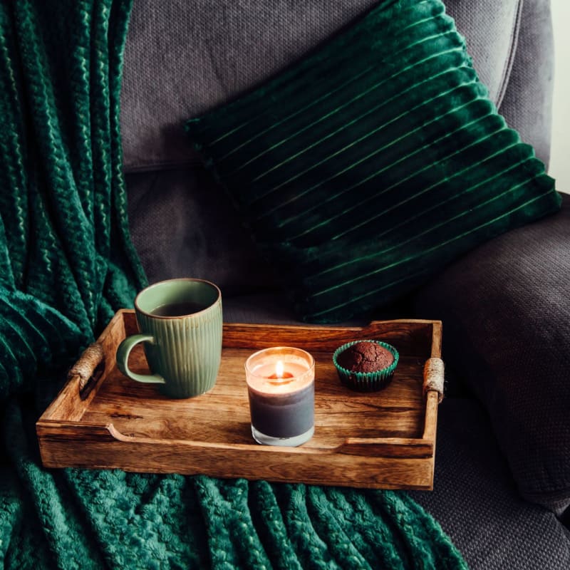 Model living space with couch and green accents at The Adair in Charlotte, North Carolina