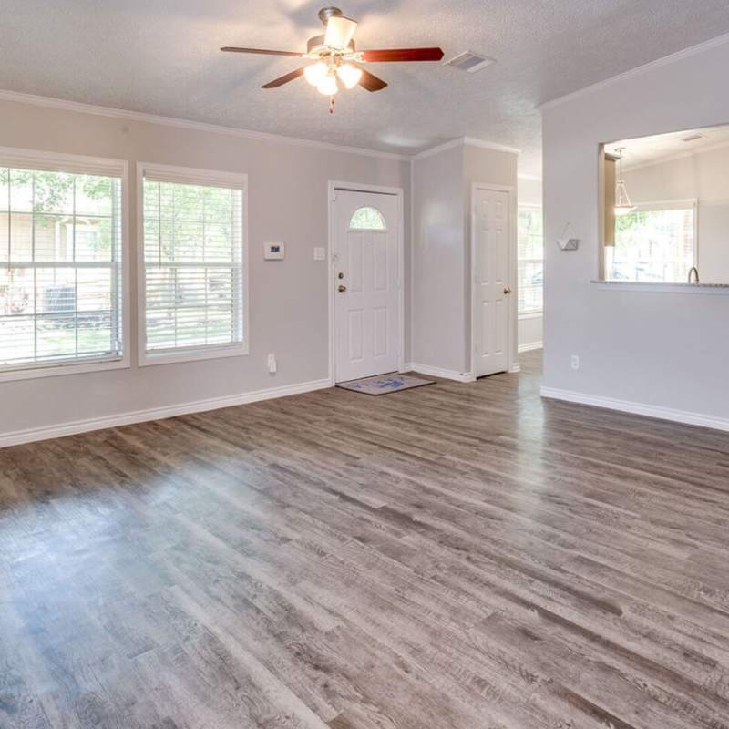Living room with hardwood flooring at Waterstone Place Apartments in Stafford, Texas