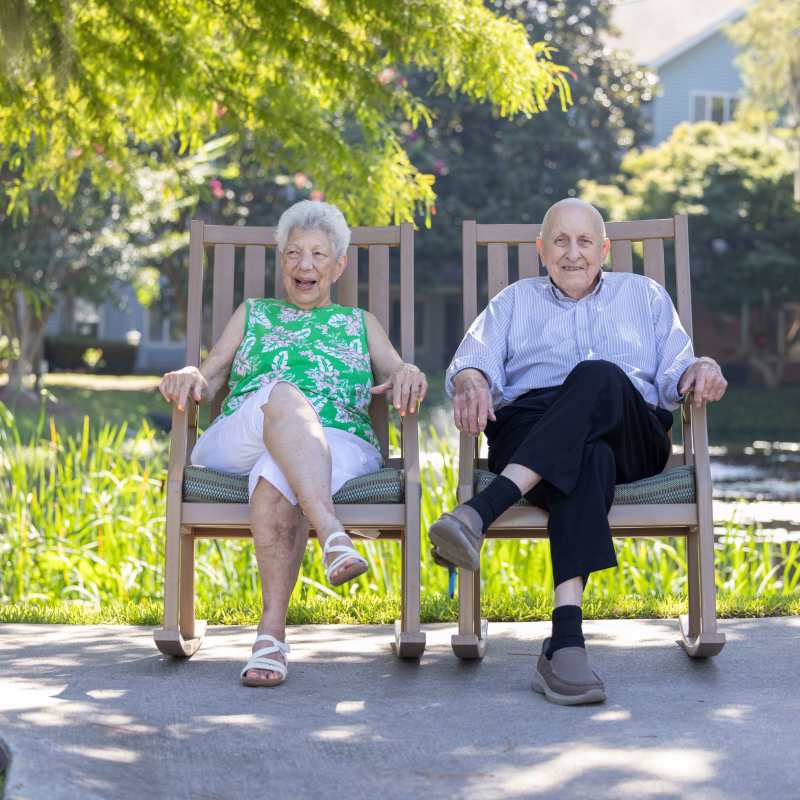 A senior man and woman sitting on rocking chairs Barclay House of Tarboro in Tarboro, North Carolina