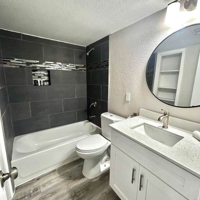 Bathroom with mirror, tub and storage space at Troup Townhomes in Troup, Texas