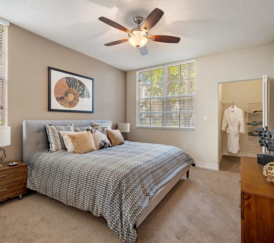 Model bedroom with ceiling fan and plush carpeting at Fountain House Apartments in Miami Lakes, Florida