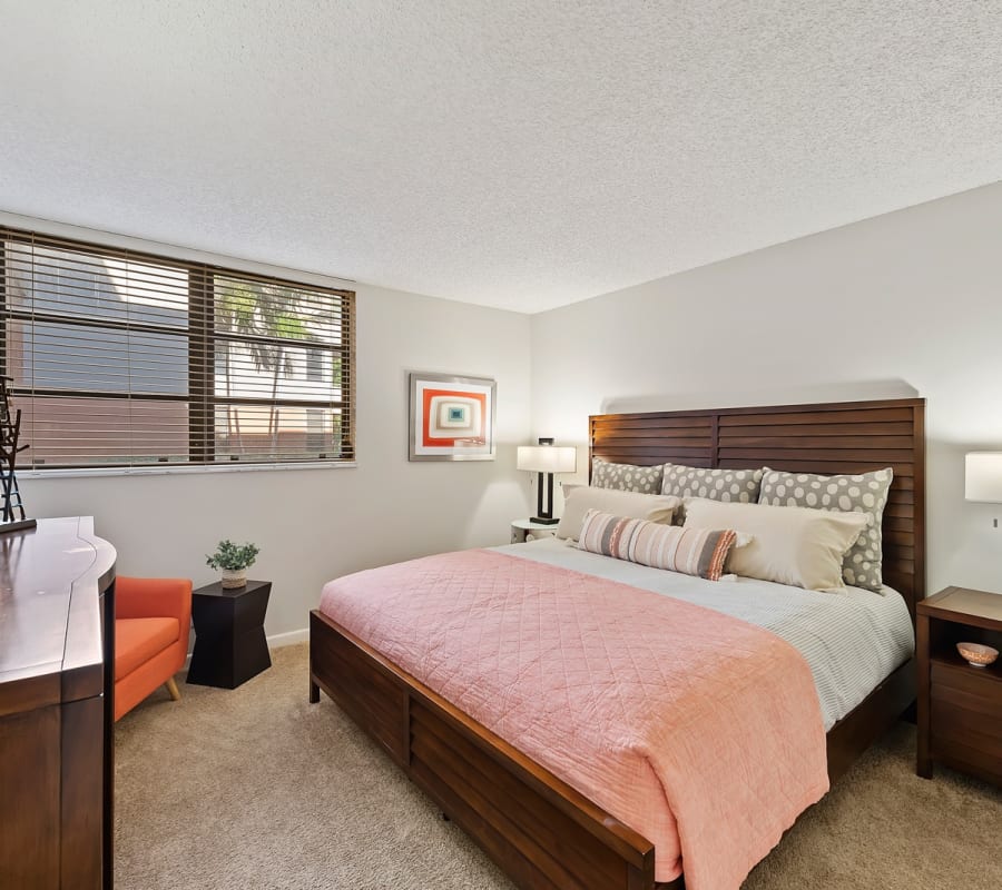 Model bedroom with plush carpeting at New Barn Apartments in Miami Lakes, Florida