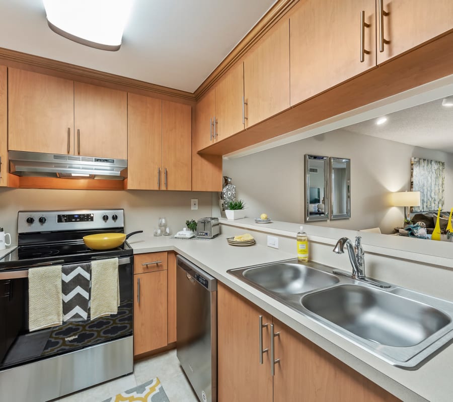 Fully equipped kitchen with stainless steel appliances at Meadow Walk Apartments in Miami Lakes, Florida