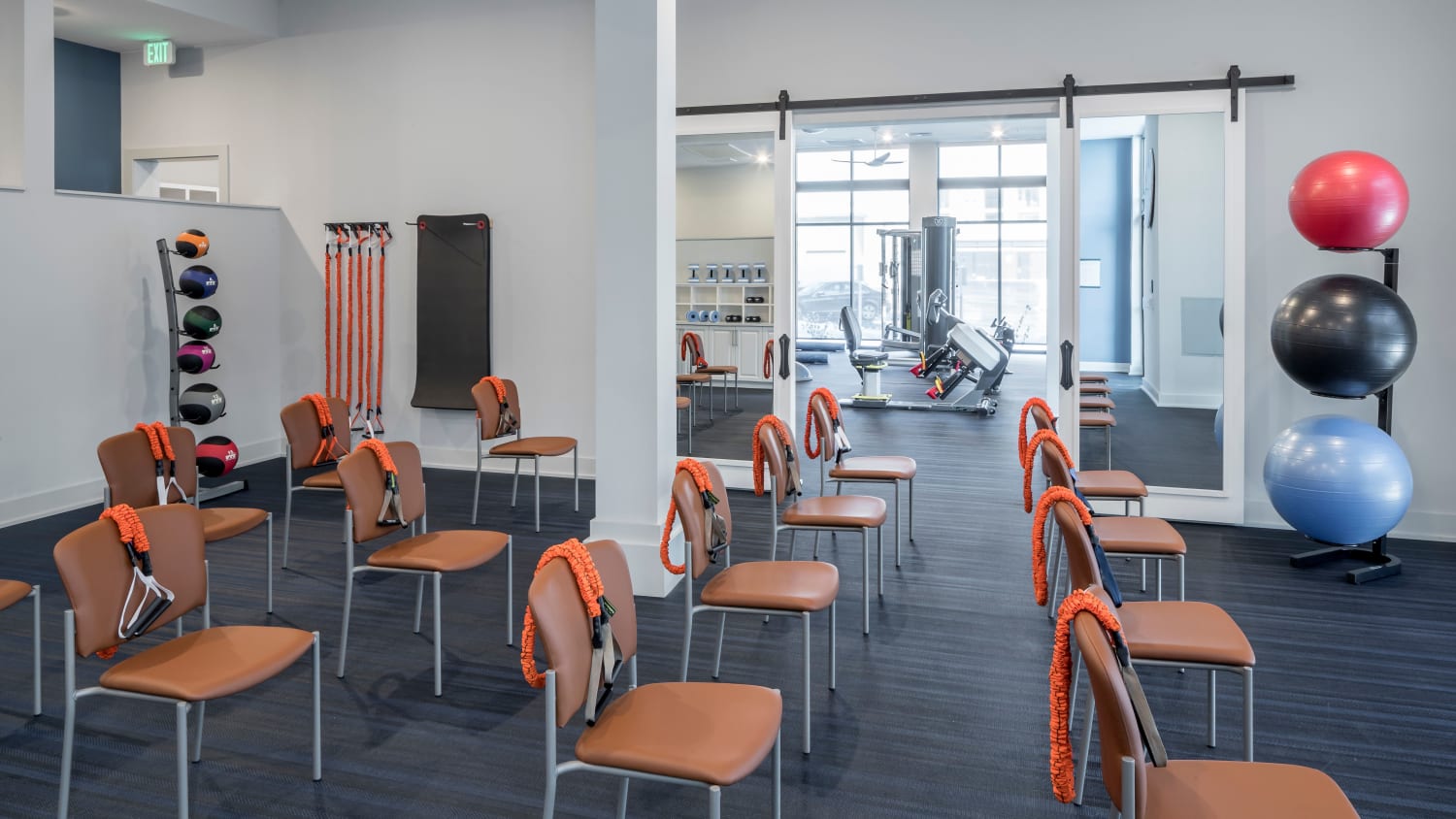 Exercise room at our over 55 apartments in Lakewood, CO, featuring spin bikes, weights, and exercise equipment. 