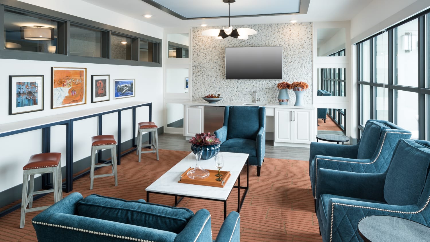 Common lounge at our active adult apartments in Lakewood, CO, featuring cushioned seating and a flat screen TV. 