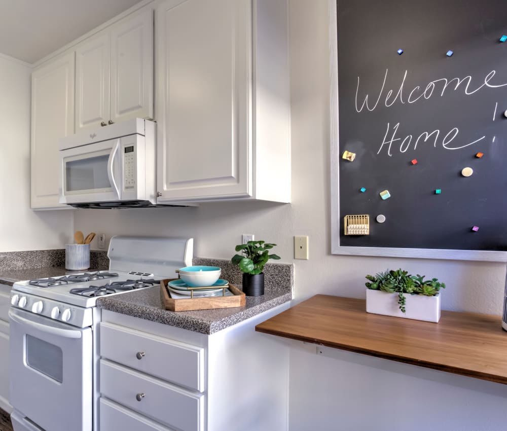 Modern kitchen with bright white appliances and the living area in the background in a model home at Sofi Thousand Oaks in Thousand Oaks, California