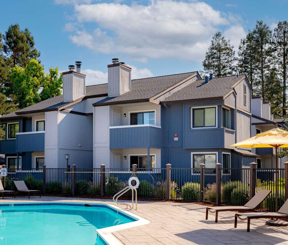 A pool with a building and a fence at Park Ridge Apartment Homes in Rohnert Park, California