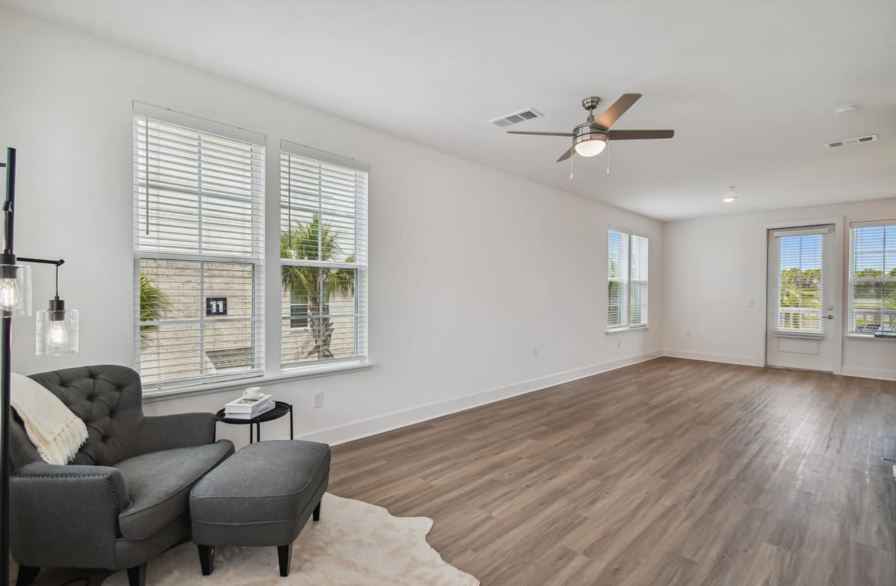 Apartments for Rent in Ponte Vedra Beach, FL - Cadence at Nocatee - Spacious Vinyl Plank Flooring Living Room with Five Windows and Door to Balcony.