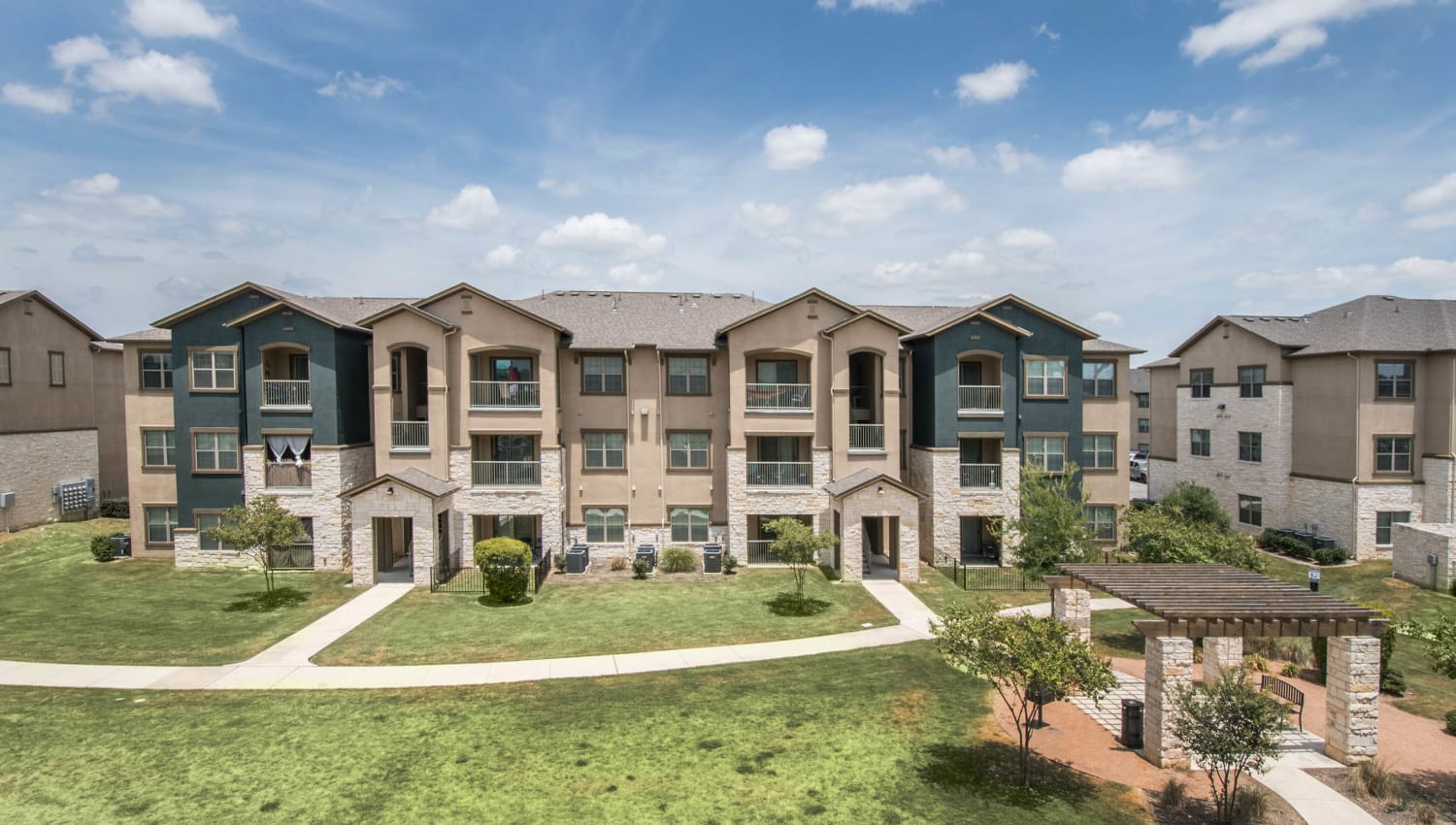 Well-maintained grounds outside resident buildings at Carrington Oaks in Buda, Texas