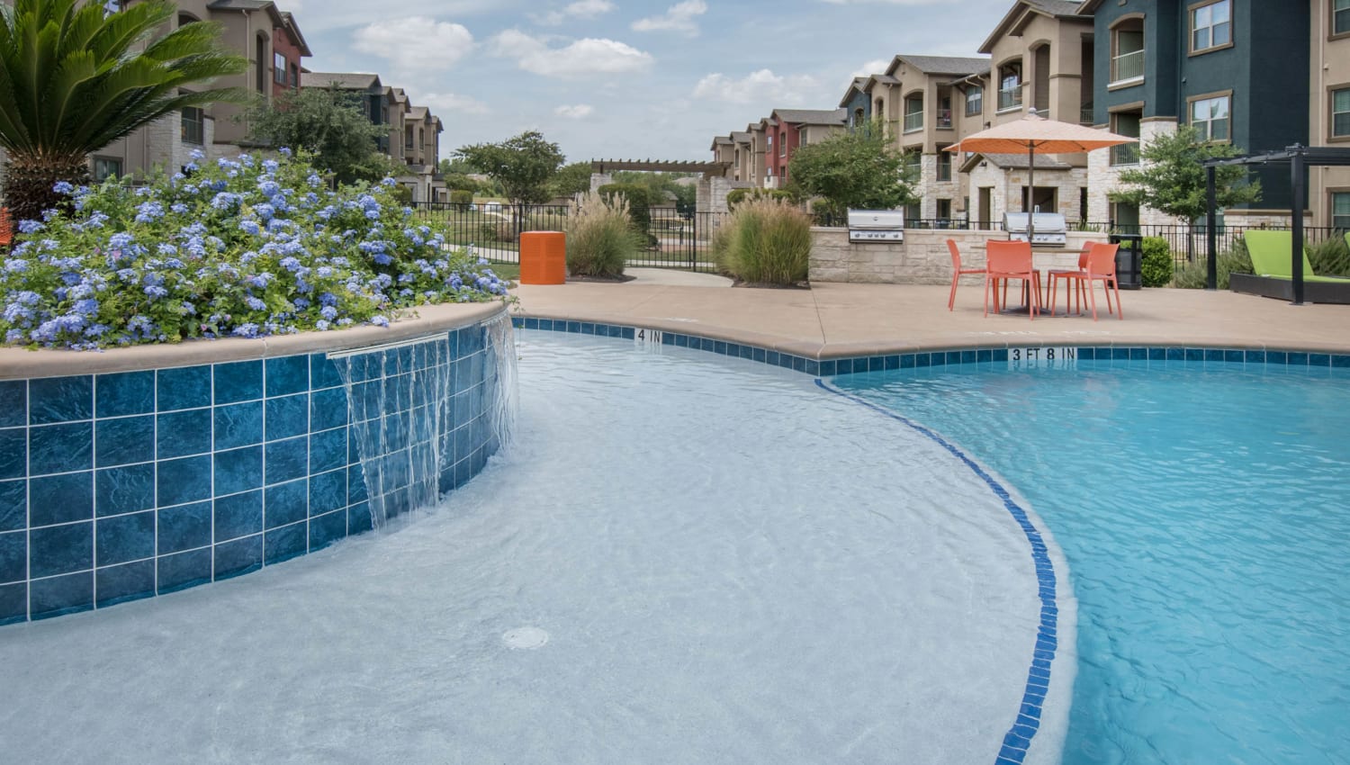 Tanning shelf surrounding the fountain in the pool at Carrington Oaks in Buda, Texas