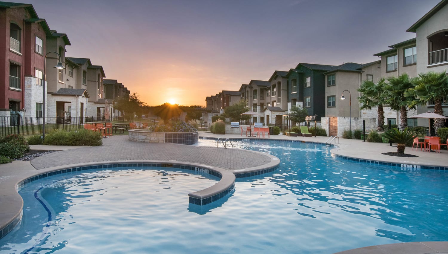 View of the sun rising above the swimming pool at Carrington Oaks in Buda, Texas