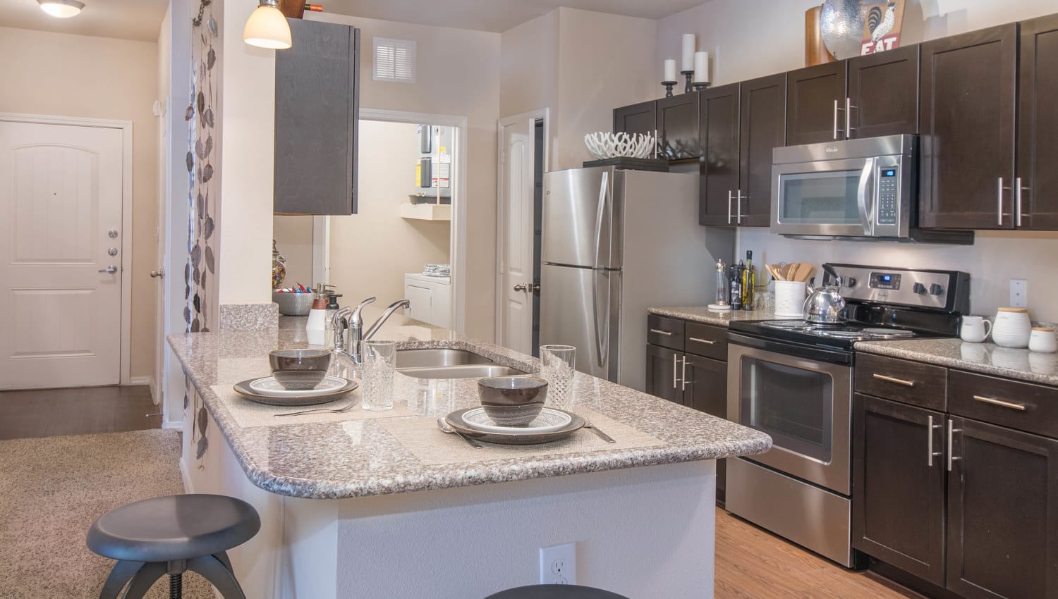 Gourmet kitchen in the open-concept floor plan of a model apartment home at Carrington Oaks in Buda, Texas