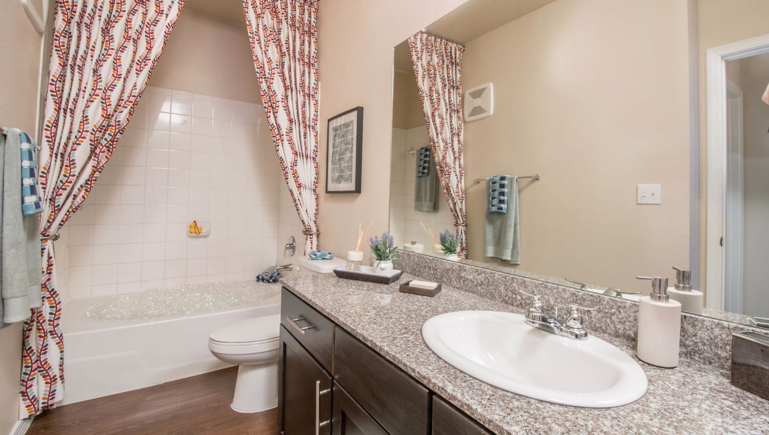 Guest bathroom with a granite countertop in a model apartment at Carrington Oaks in Buda, Texas