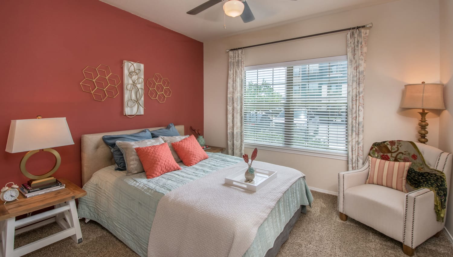 Ceiling fan and plush carpeting in the primary bedroom of a model home at Carrington Oaks in Buda, Texas