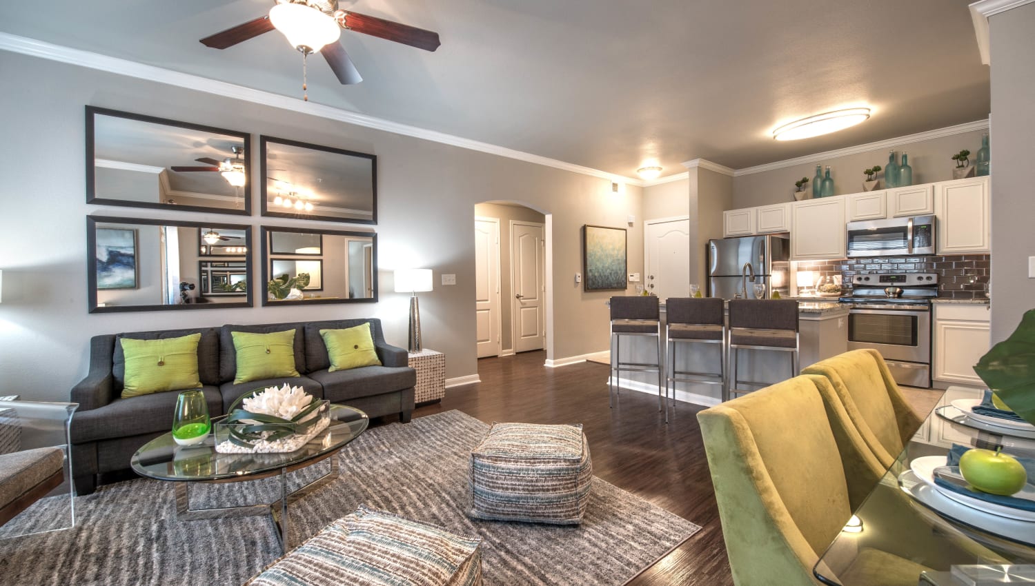 Model apartment's living space with hardwood floors and modern furnishings at Olympus Las Colinas in Irving, Texas