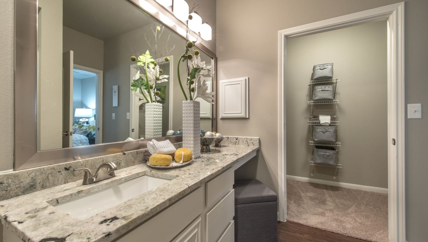 Guest bathroom with a granite countertop in a model home at Olympus Las Colinas in Irving, Texas