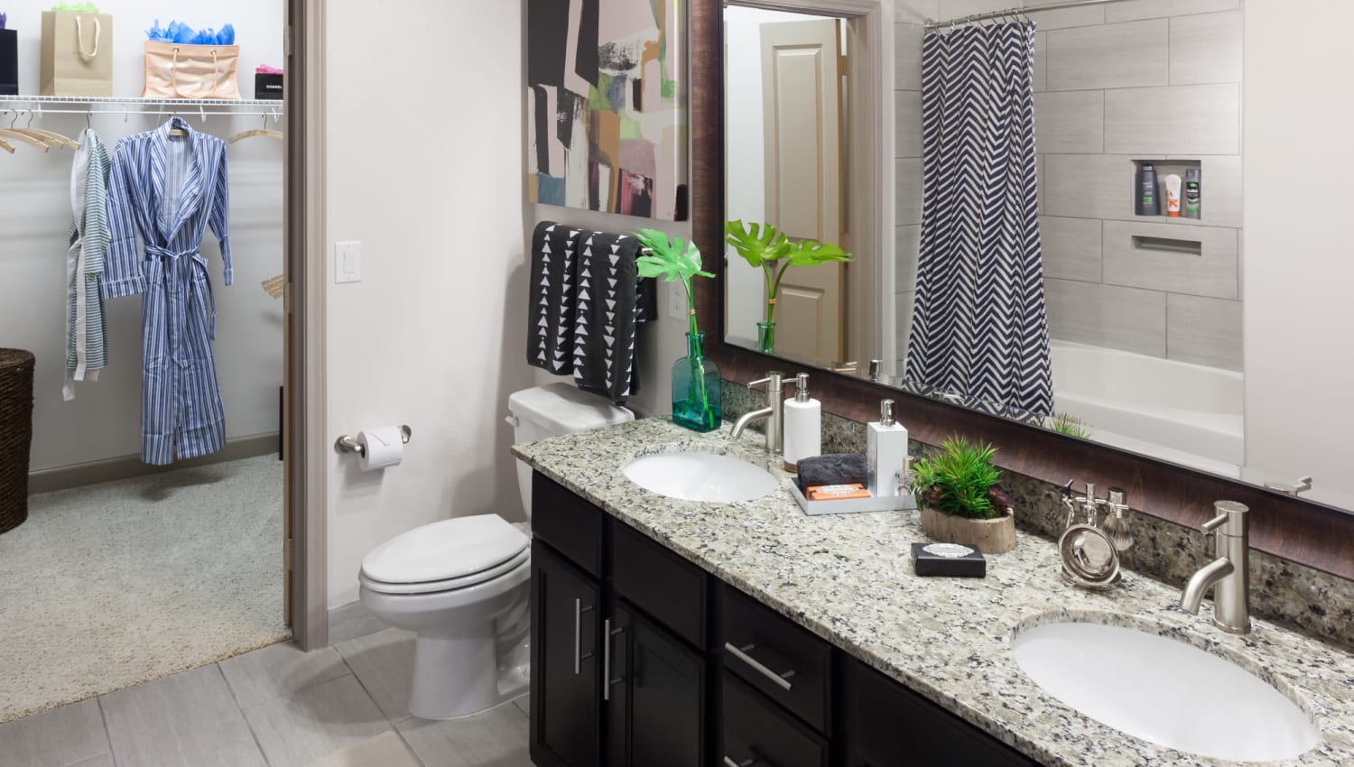Bathroom with double sink vanity in model home at Olympus Auburn Lakes in Spring, Texas