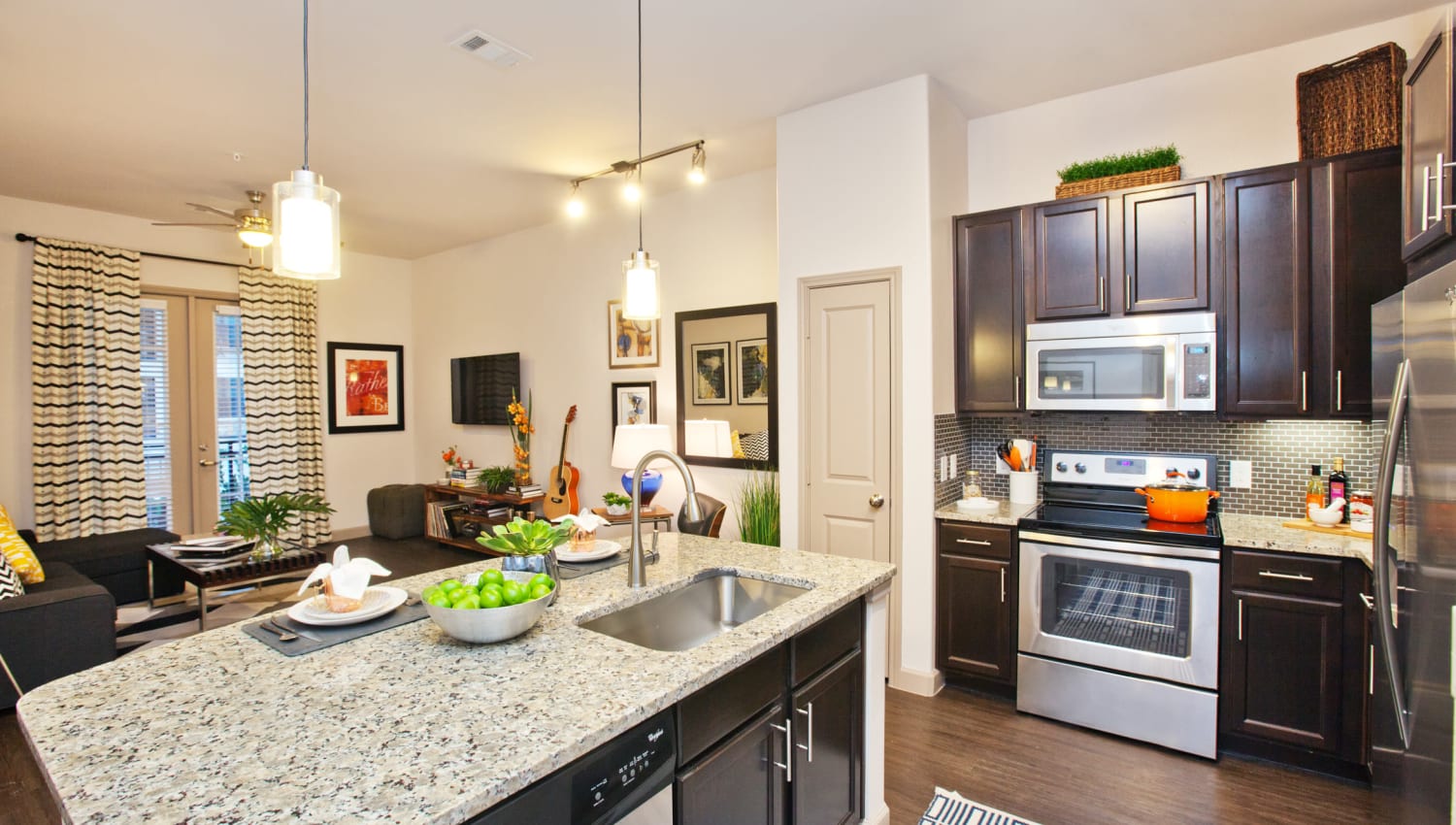 Kitchen island and stainless-steel appliances at Olympus Auburn Lakes in Spring, Texas