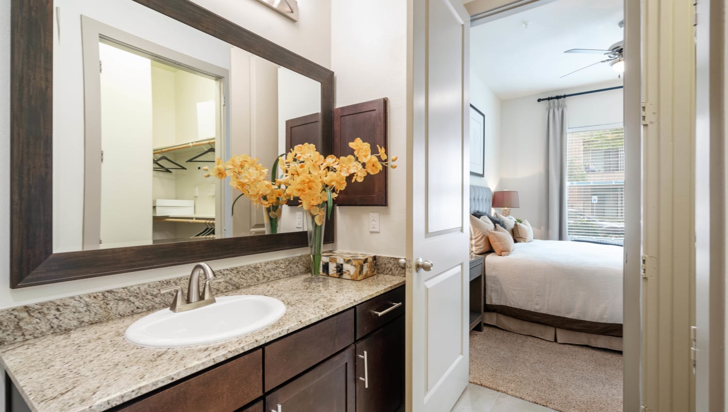 Oversized vanity mirror and a granite countertop in a model home's master bathroom at Olympus Sierra Pines in The Woodlands, Texas
