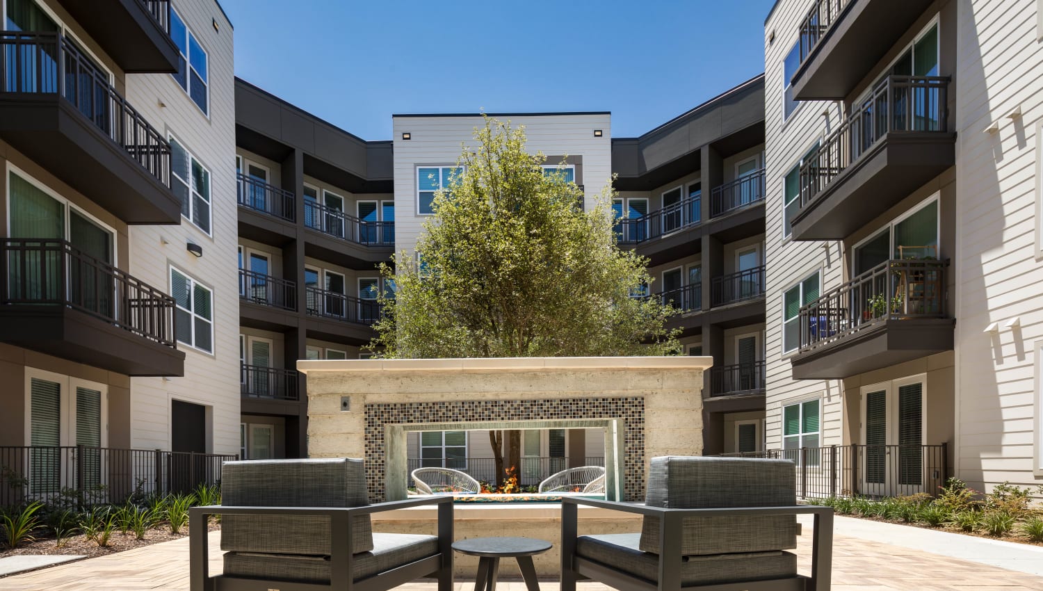 Lounge areas in the exterior courtyard between resident buildings at Lux on Main in Carrollton, Texas