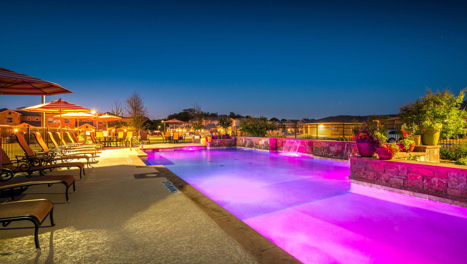 Colorful lighting at the swimming pool area at dusk at Olympus Willow Park in Willow Park, Texas