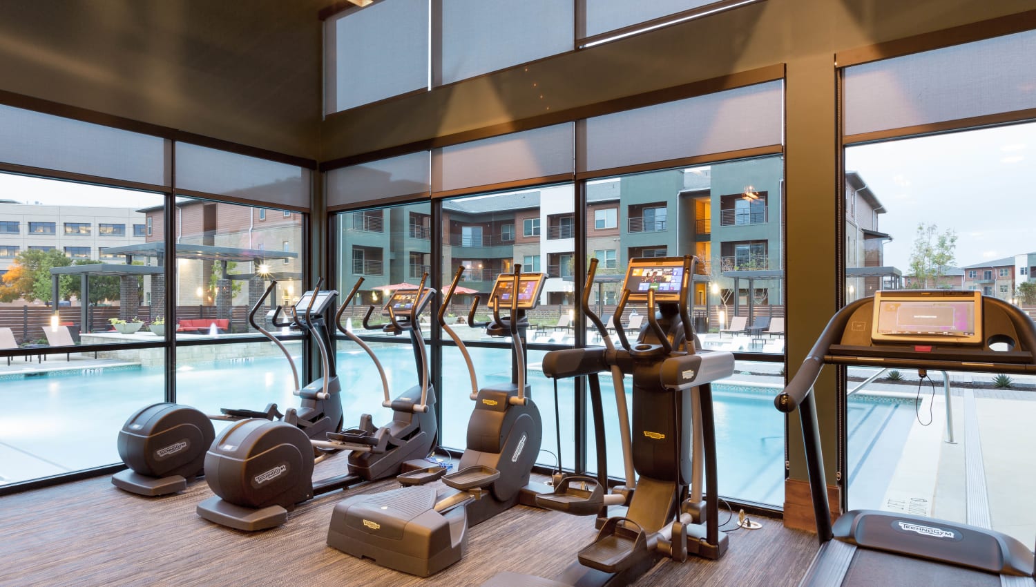 Cardio equipment with a prime view of the swimming pool at The Davis in Fort Worth, Texas