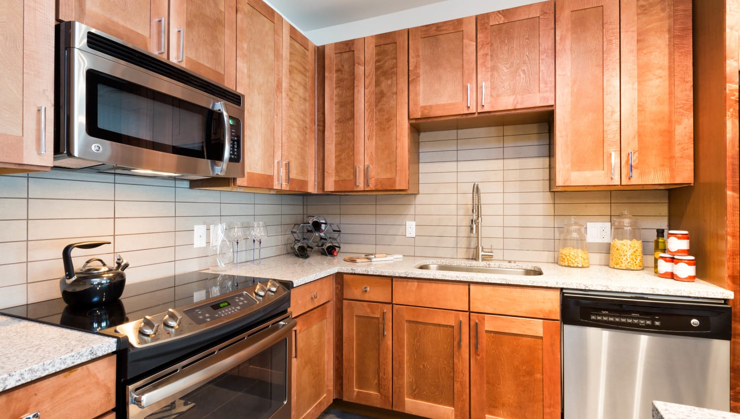 Cherry wood cabinetry in a model apartment's kitchen at The Davis in Fort Worth, Texas
