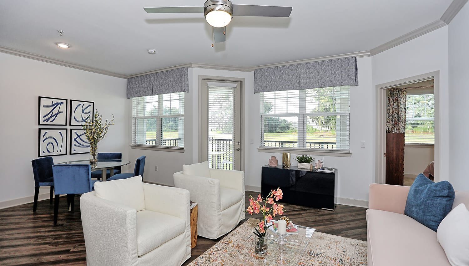Well-decorated open-concept living area with a ceiling fan in a model home at The Slate in Savannah, Georgia