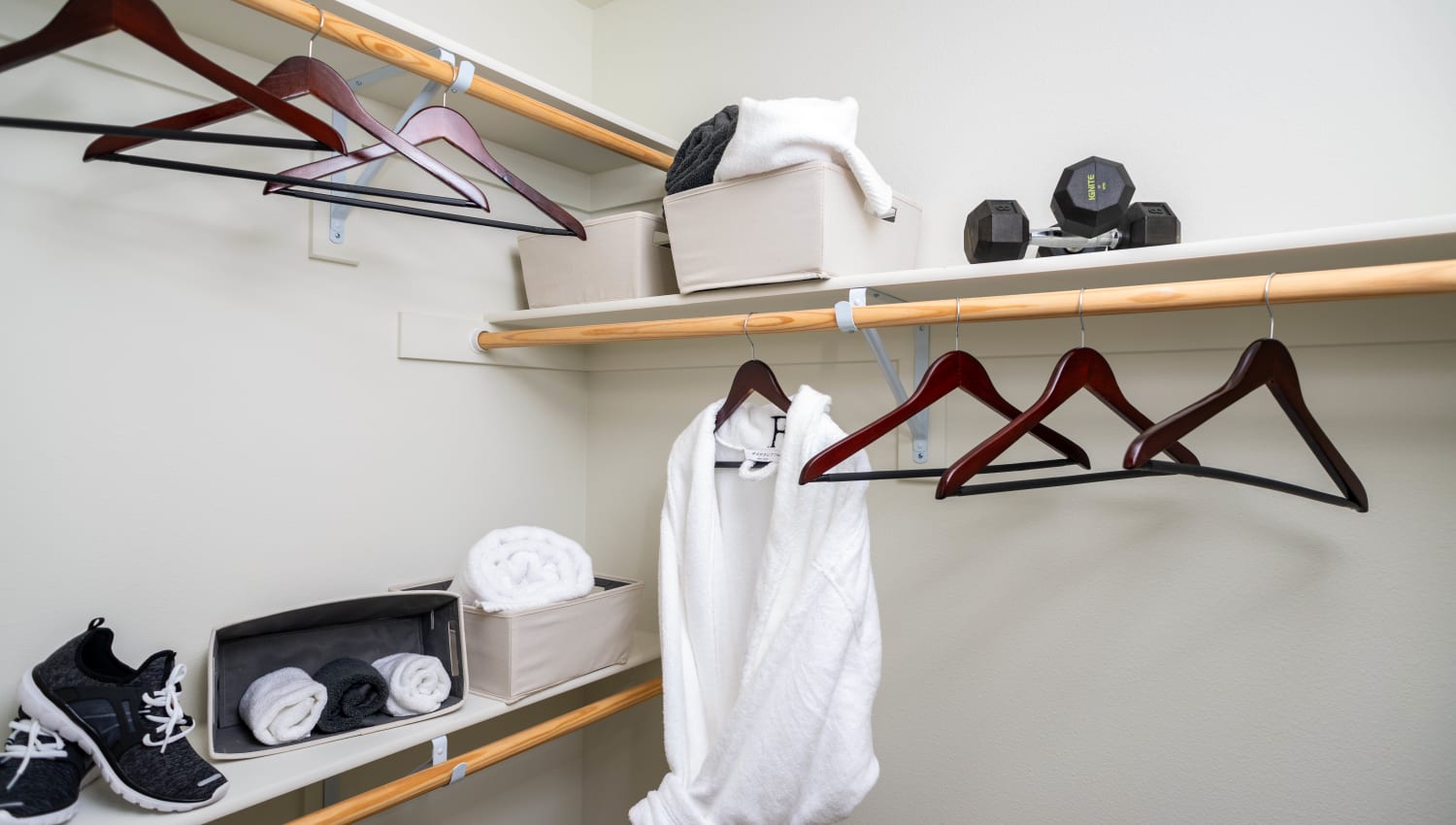 Walk-in closet with built-in shelving in a model home's bedroom at Fusion Apartments in Irvine, California
