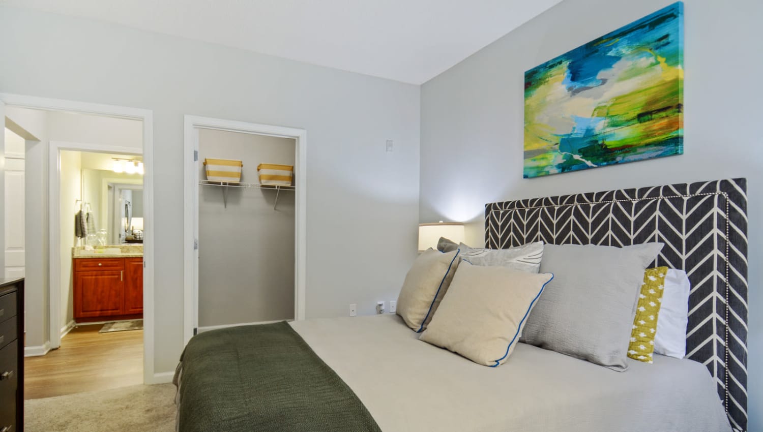 Bedroom with a walk-in closet and adjacent bathroom in a model home at Ellington Midtown in Atlanta, Georgia