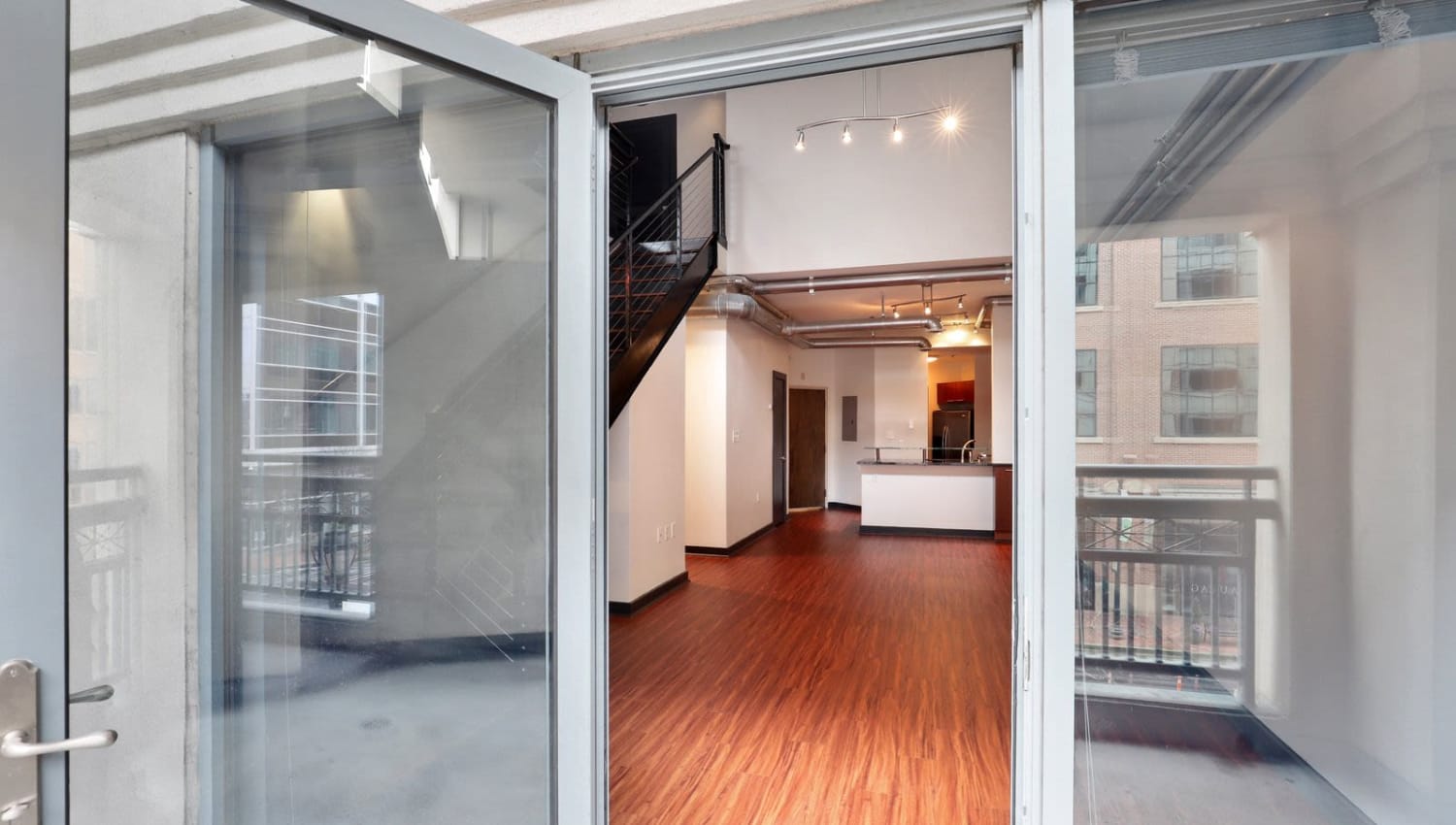 Living room with hardwood flooring and patio access at 17th Street Lofts in Atlanta, Georgia