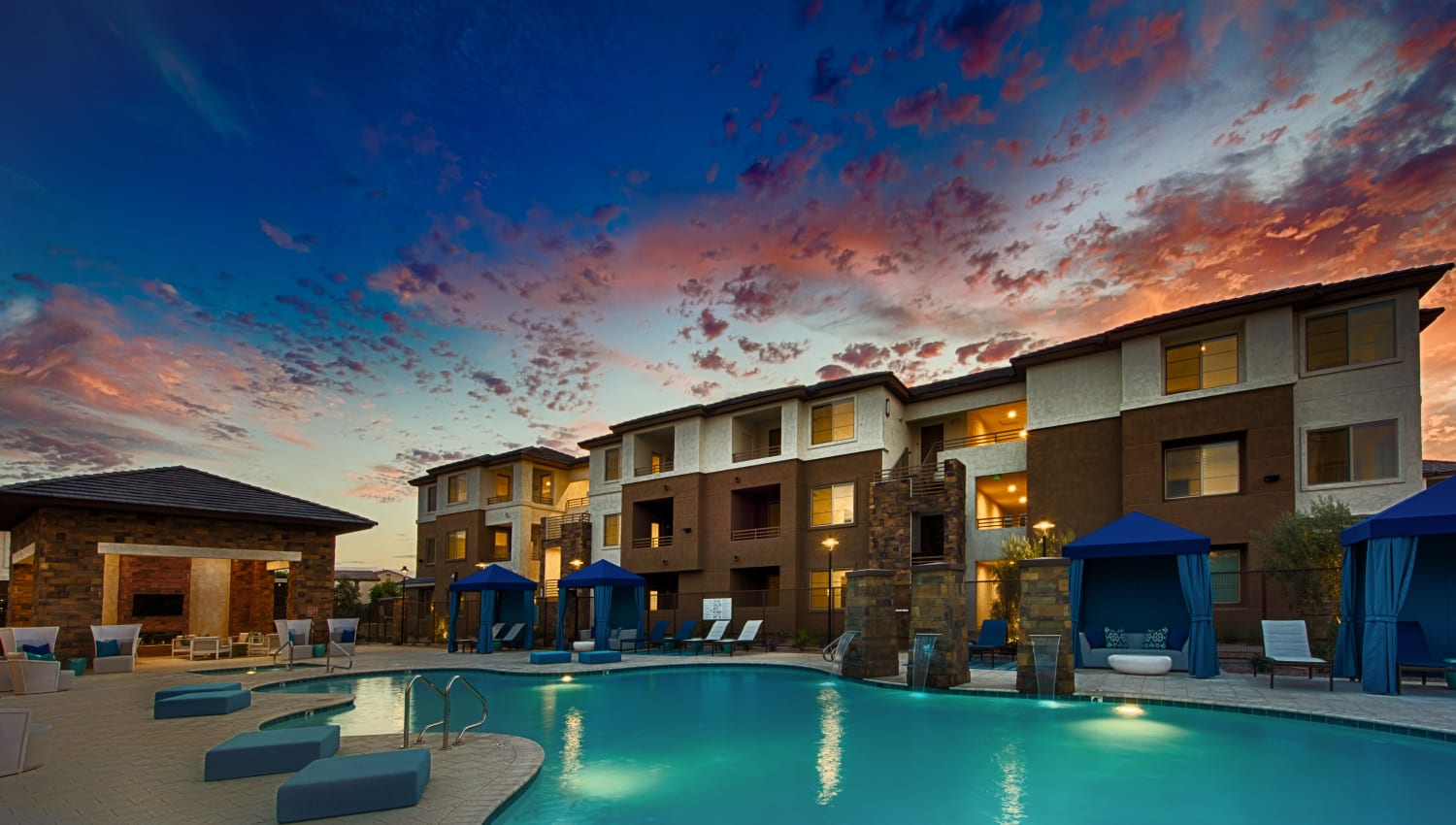 Resort-style swimming pool at dusk at Ocio Plaza Del Rio in Peoria, Arizona