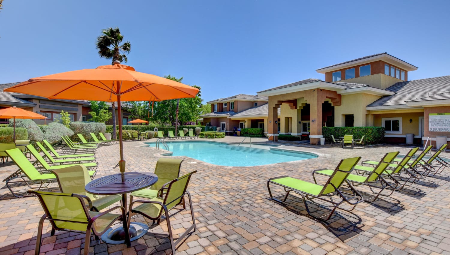 Poolside seating with umbrella at Canyon Villas Apartments in Las Vegas, Nevada
