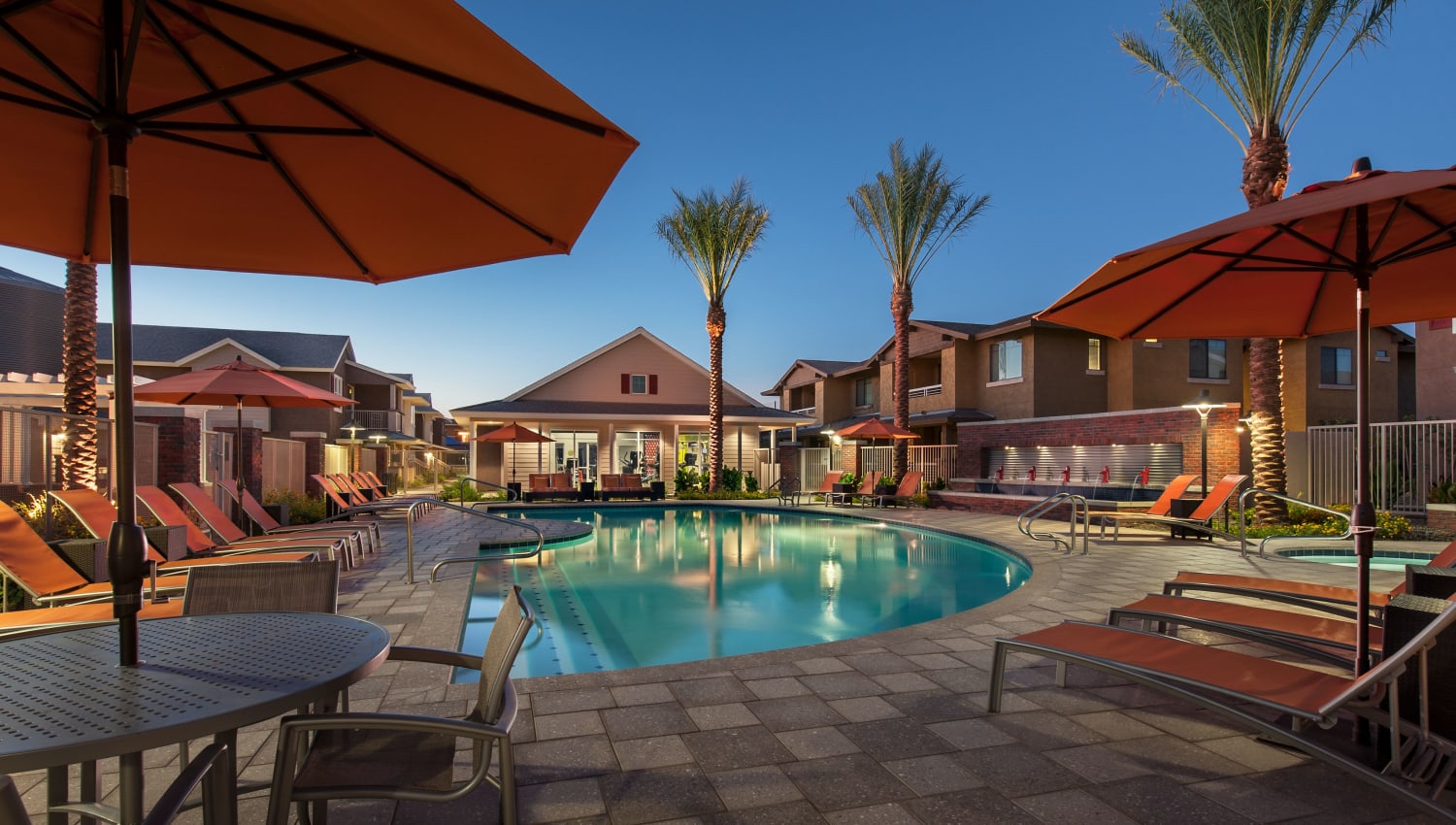 Sparkling pool and poolside seating at Highland Groves at Morrison Ranch Apartments in Gilbert, Arizona