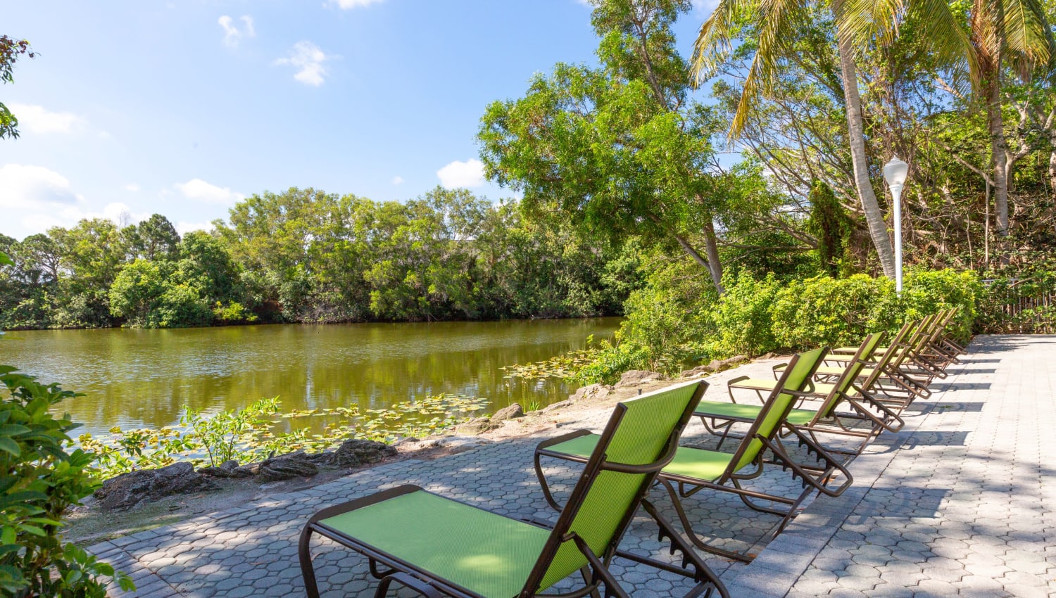 Pool seating facing the lake at Quantum Lake Villas Apartments in Boynton Beach, Florida