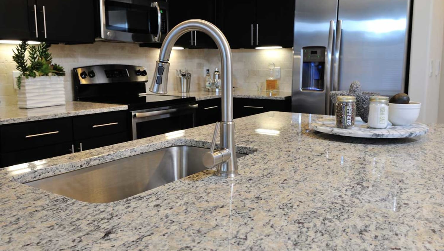 Granite counter island with stainless steel sink at Olympus Falcon Landing in Katy, Texas