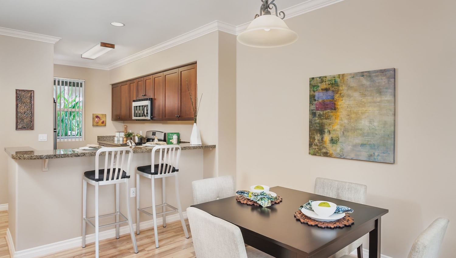 Model dining area and kitchen at The Pointe Apartments in Brea, California