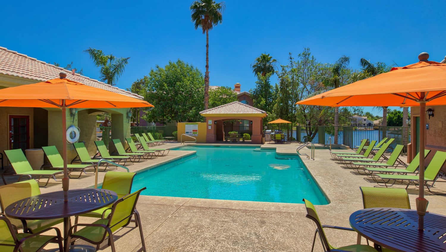 Sparkling pool and shaded seating at Serena Shores Apartments in Gilbert, Arizona